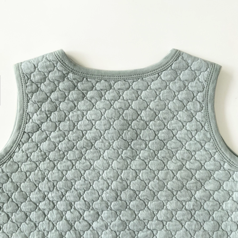 Toddler wearing Senseng quilted vest layered over long-sleeve tee, outdoors