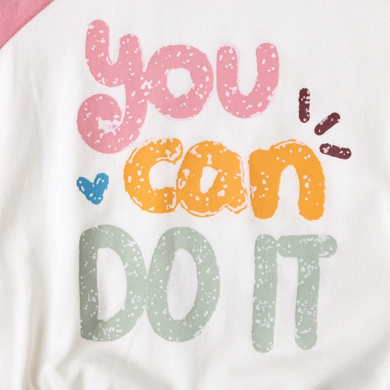 Macro view of the motivational "you can DO IT" graphic, tinted with natural plant extracts on white organic cotton jersey.