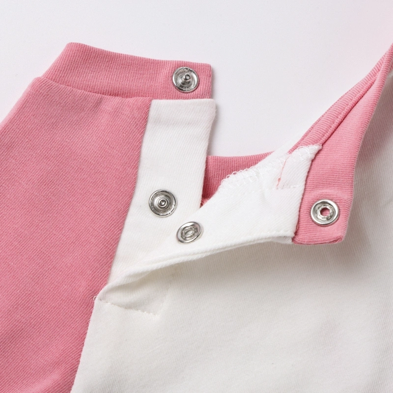 Detailed view of the open raglan shoulder snap placket, engineered for stress-free over-the-head infant dressing.