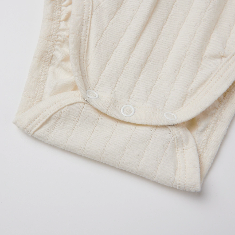 Baby girl wearing Senseng organic cotton pointelle strappy bodysuit, plant-dyed, breathable and eco-friendly