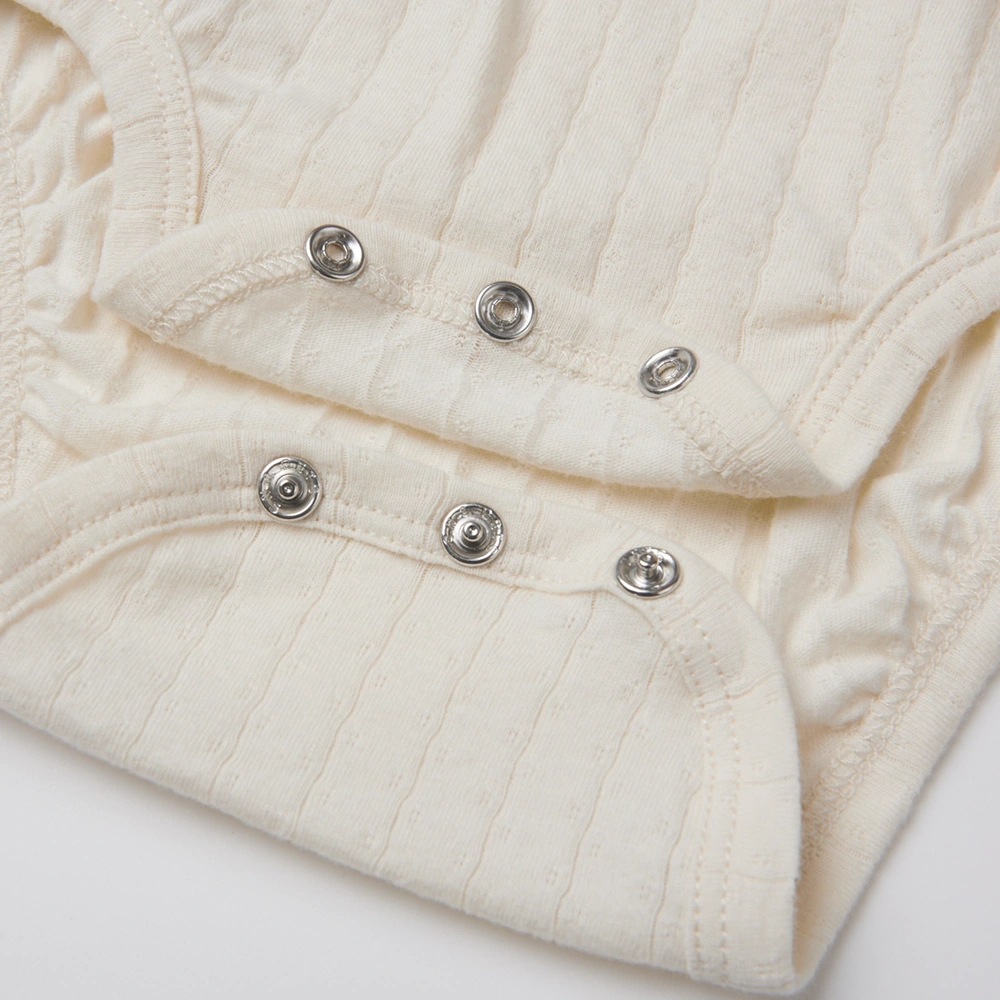 Baby girl wearing Senseng organic cotton pointelle strappy bodysuit, plant-dyed, breathable and eco-friendly