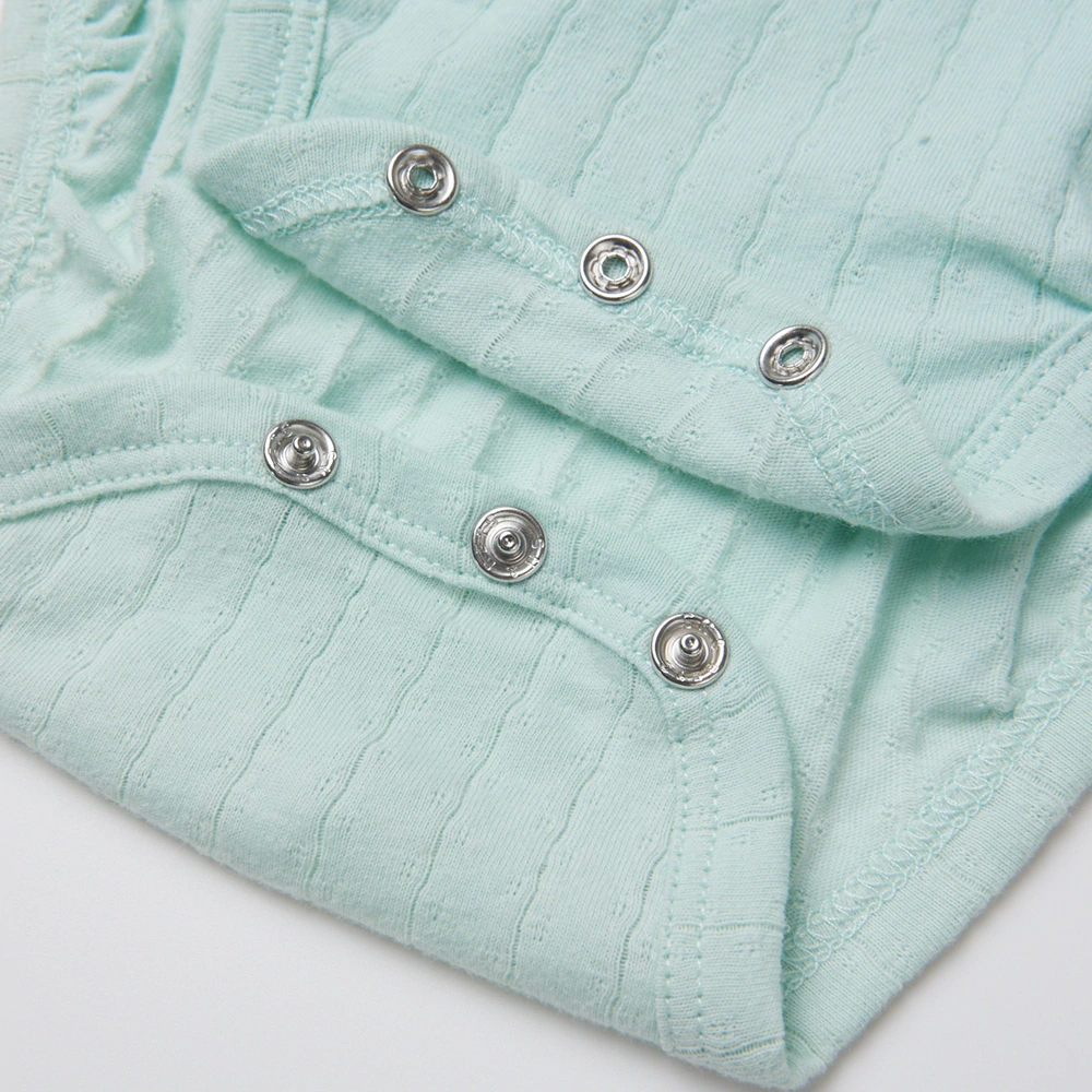 Baby girl wearing Senseng organic cotton pointelle strappy bodysuit, plant-dyed, breathable and eco-friendly