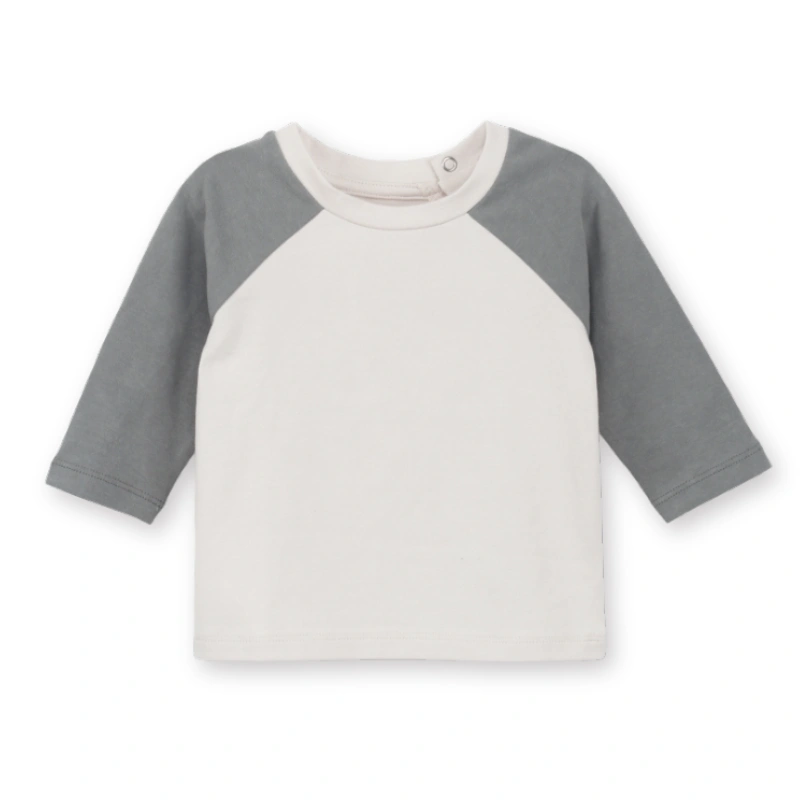 Front flat view of SENSENG organic cotton baby raglan long sleeve tee showcasing the plant-dyed natural powder puff body and flint gray sleeves.