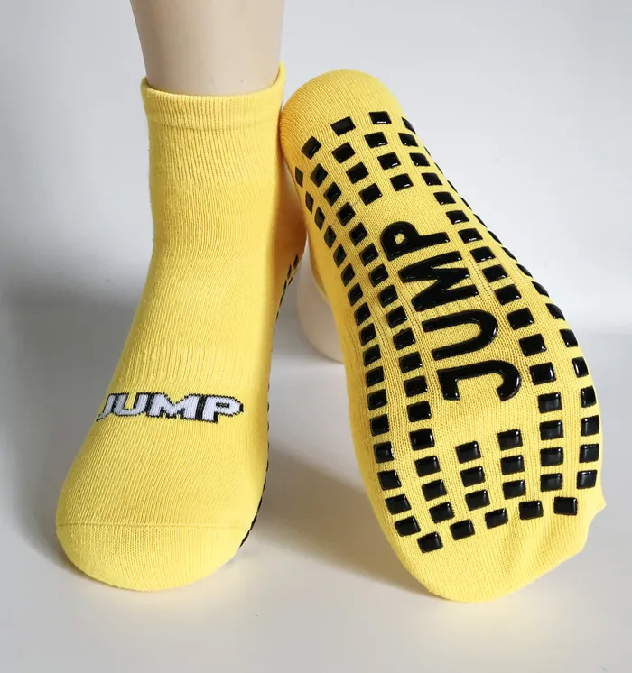 Yellow grip socks with silicone traction patterns on the sole, showing non-slip design