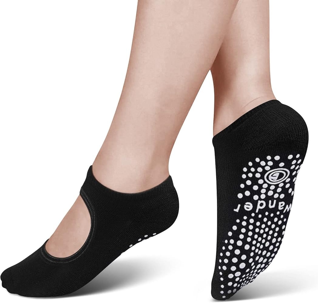 Ballet-style grip socks contacting indoor floor during heel-raised balance position