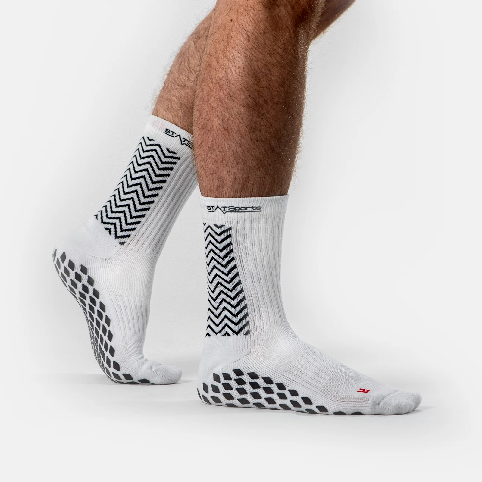 White crew grip socks with silicone anti-slip sole and zigzag grip pattern for sports and studio training
