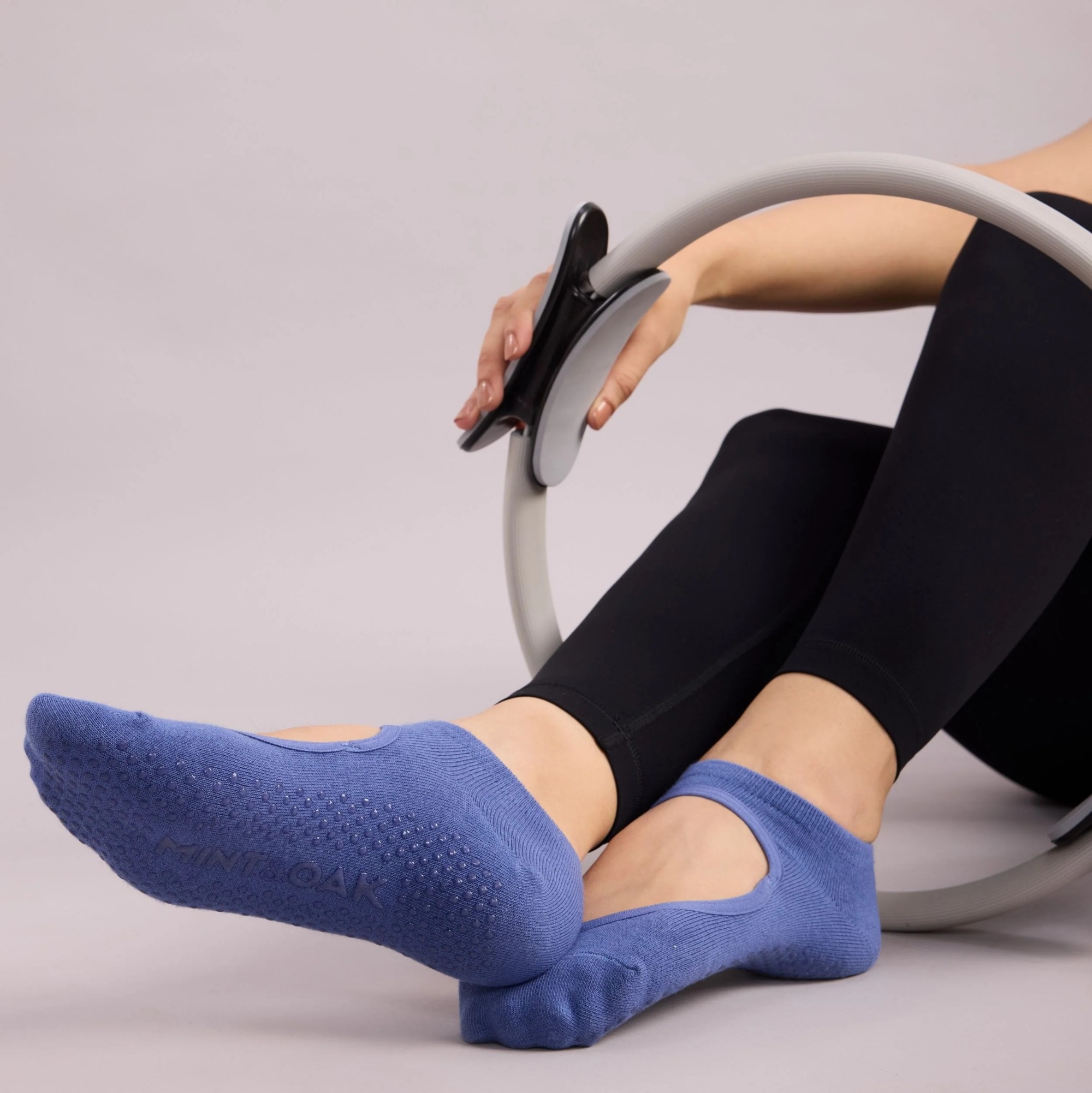 blue grip socks worn during pilates ring exercise demonstrating controlled traction and balance