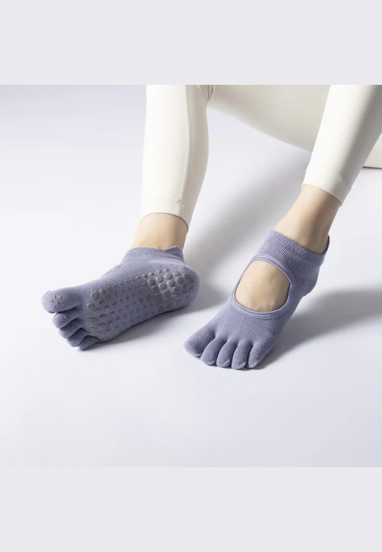 Non-slip five-toe grip socks worn on smooth flooring, illustrating foot contact and traction distribution during standing balance