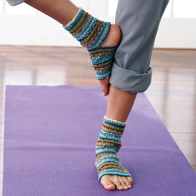Ankle length grip socks used during balance focused indoor exercise on yoga mat surface