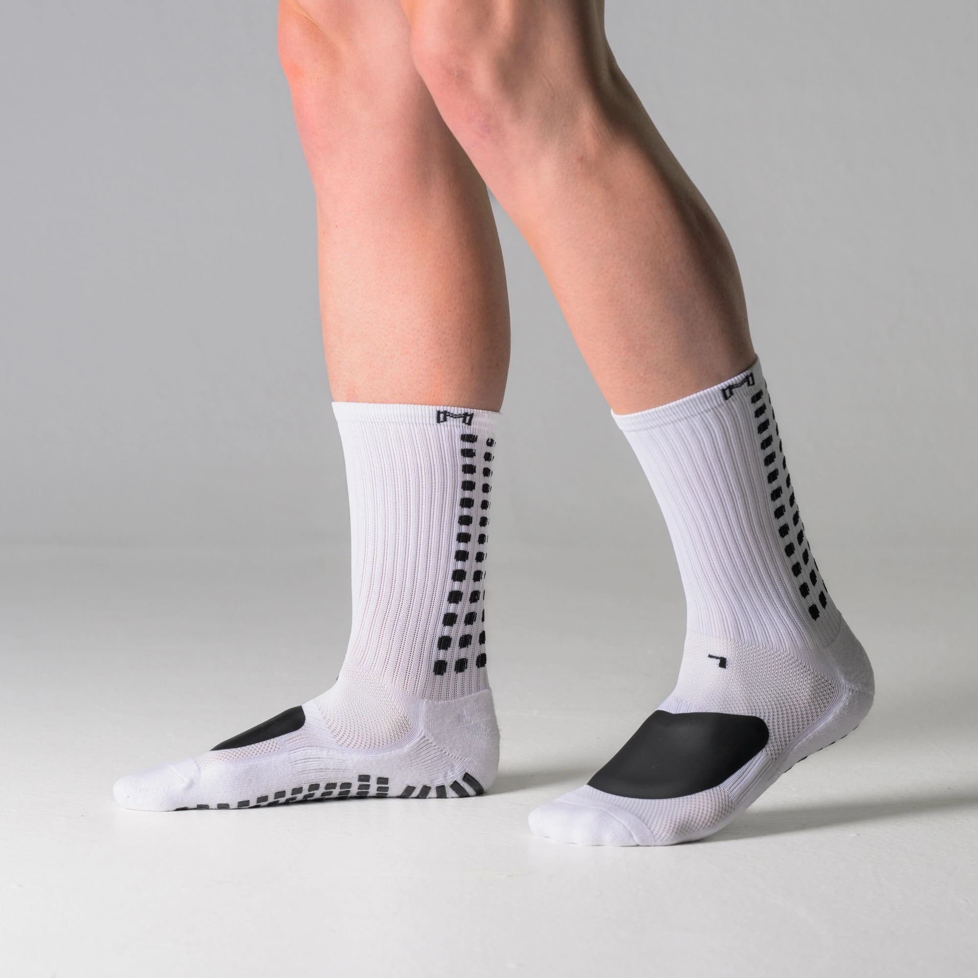 Grip socks with anti-slip patterns illustrating stability and traction during standing posture
