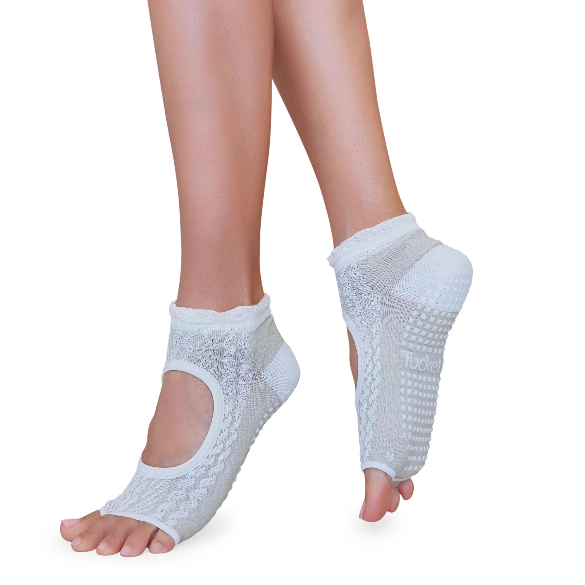 Open-toe grip socks contacting smooth indoor floor surface during barefoot-style balance stance