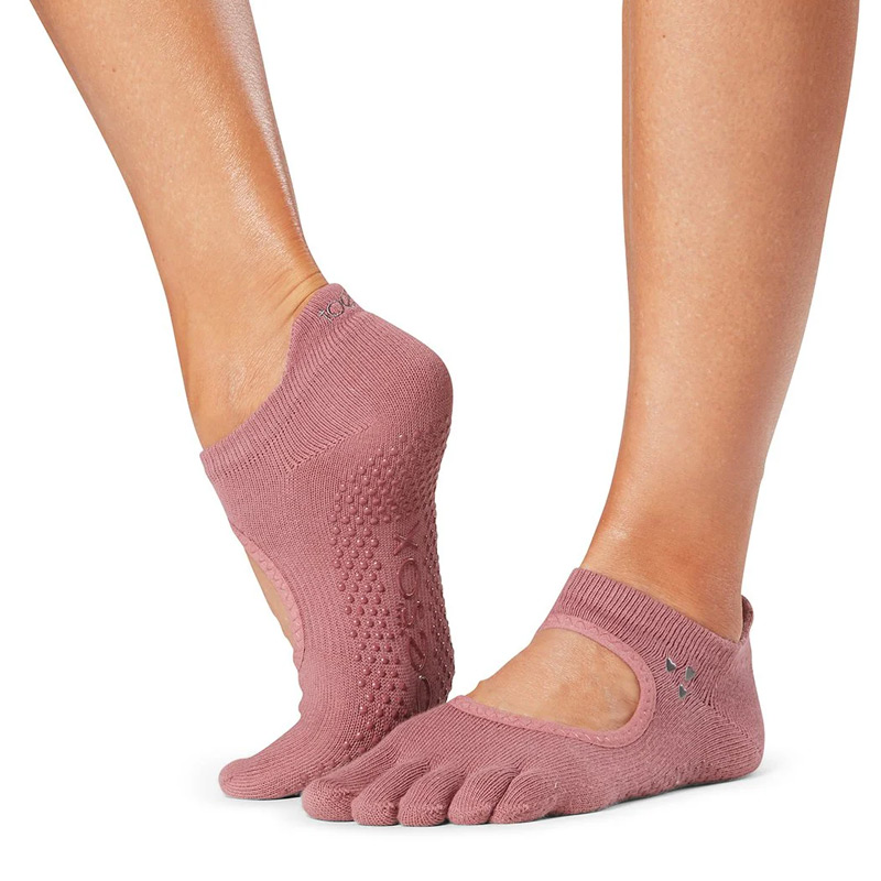 Feet wearing pink five-toe grip socks with dotted traction on the sole, shown against a white background