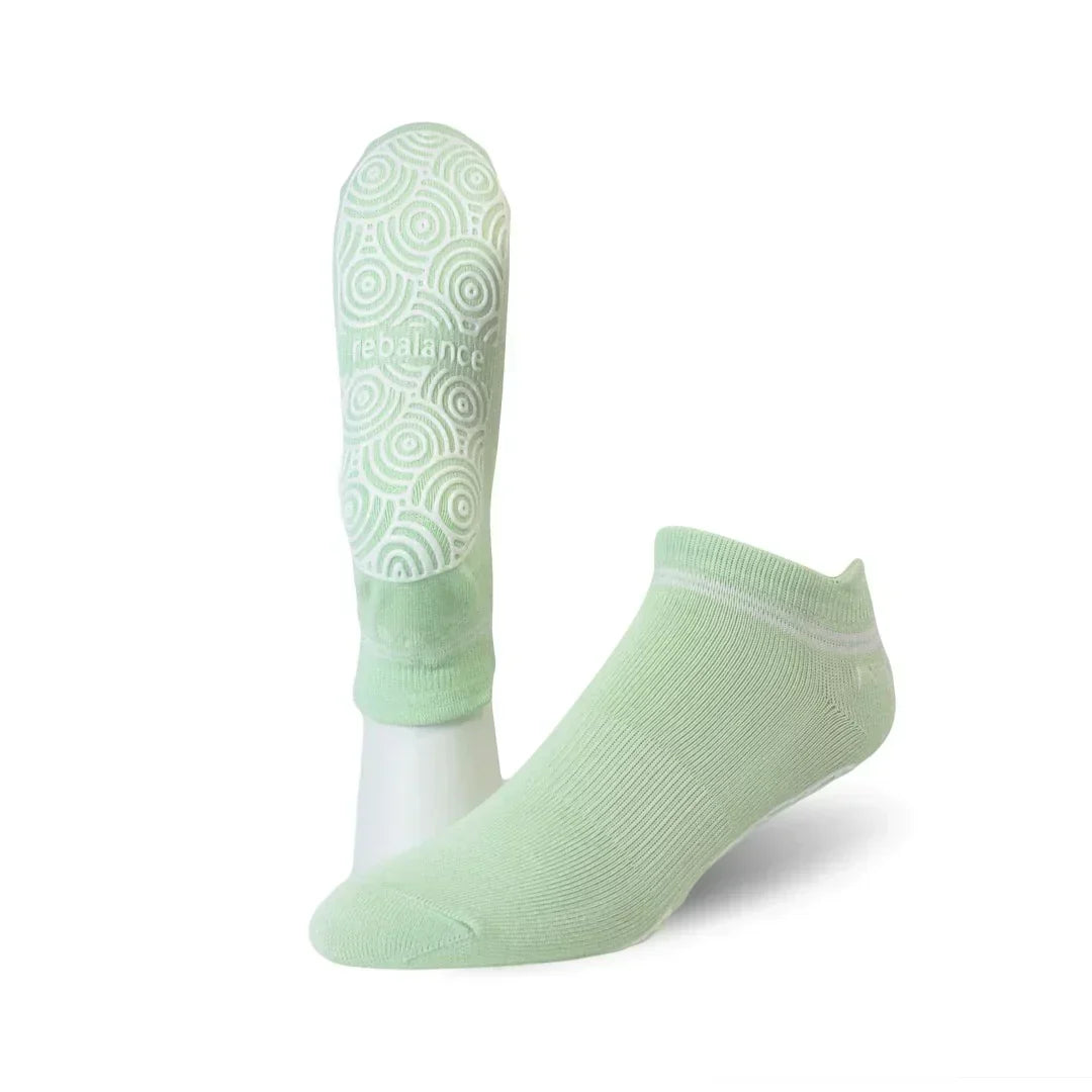 light green ankle grip socks with circular silicone grip pattern on the sole for indoor floor stability