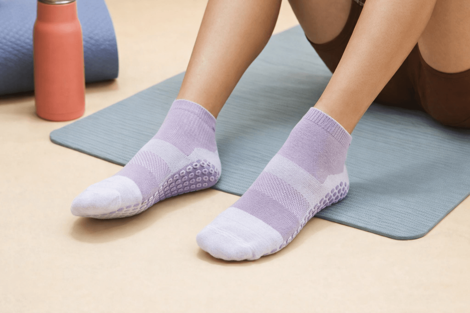 private label pilates grip socks in pastel purple on yoga mat, branded pilates socks for studio and home workouts