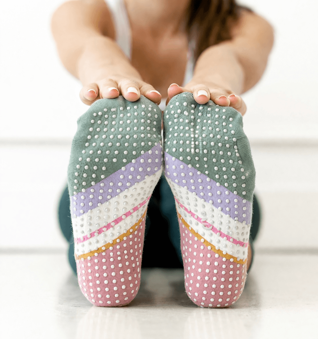 Close up sole of branded yoga socks with grip pattern, colorful private label yoga grip socks for training
