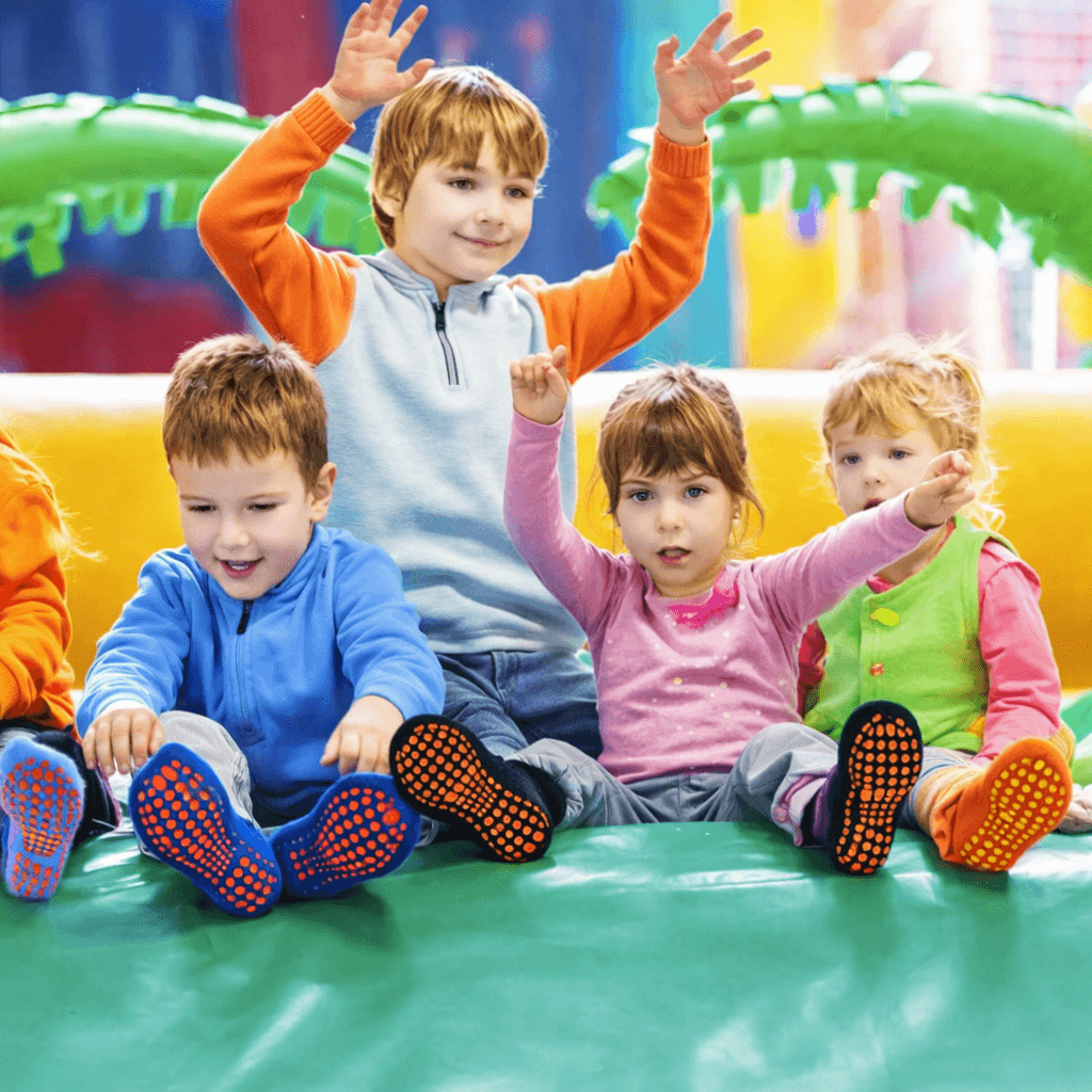 kids jumping in trampoline park wearing custom trampoline socks, durable trampoline grip socks OEM designed for safety and performance in trampoline parks