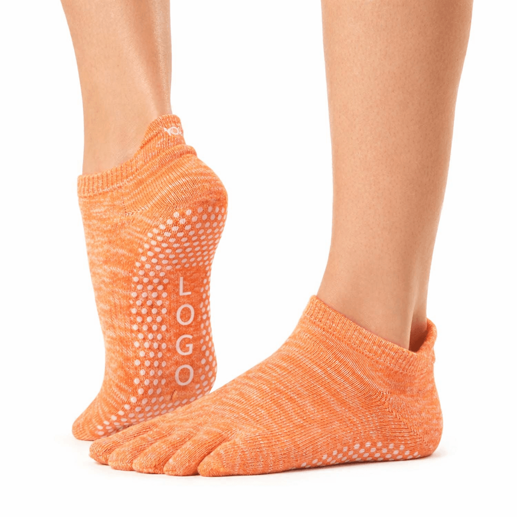 Orange five-toe grip socks with anti-slip silicone dots on sole, low-cut design for Pilates and yoga use, close-up product view