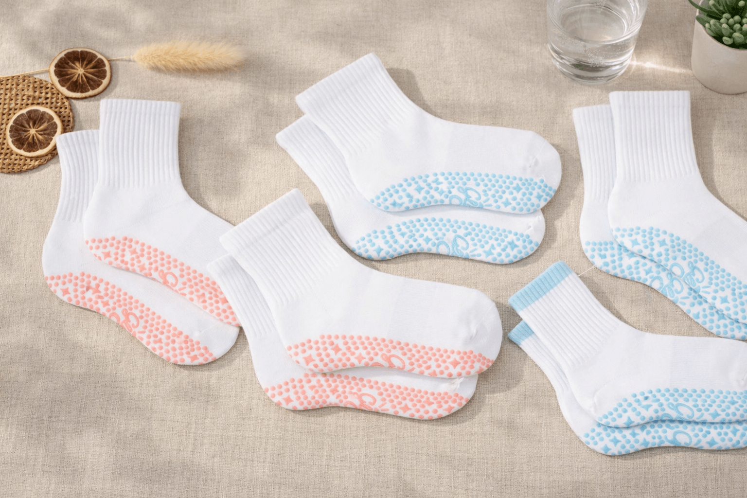 Multiple pairs of white non-slip grip socks displayed on fabric background, ideal products from a grip socks wholesale distributor and socks distributor bulk supplier