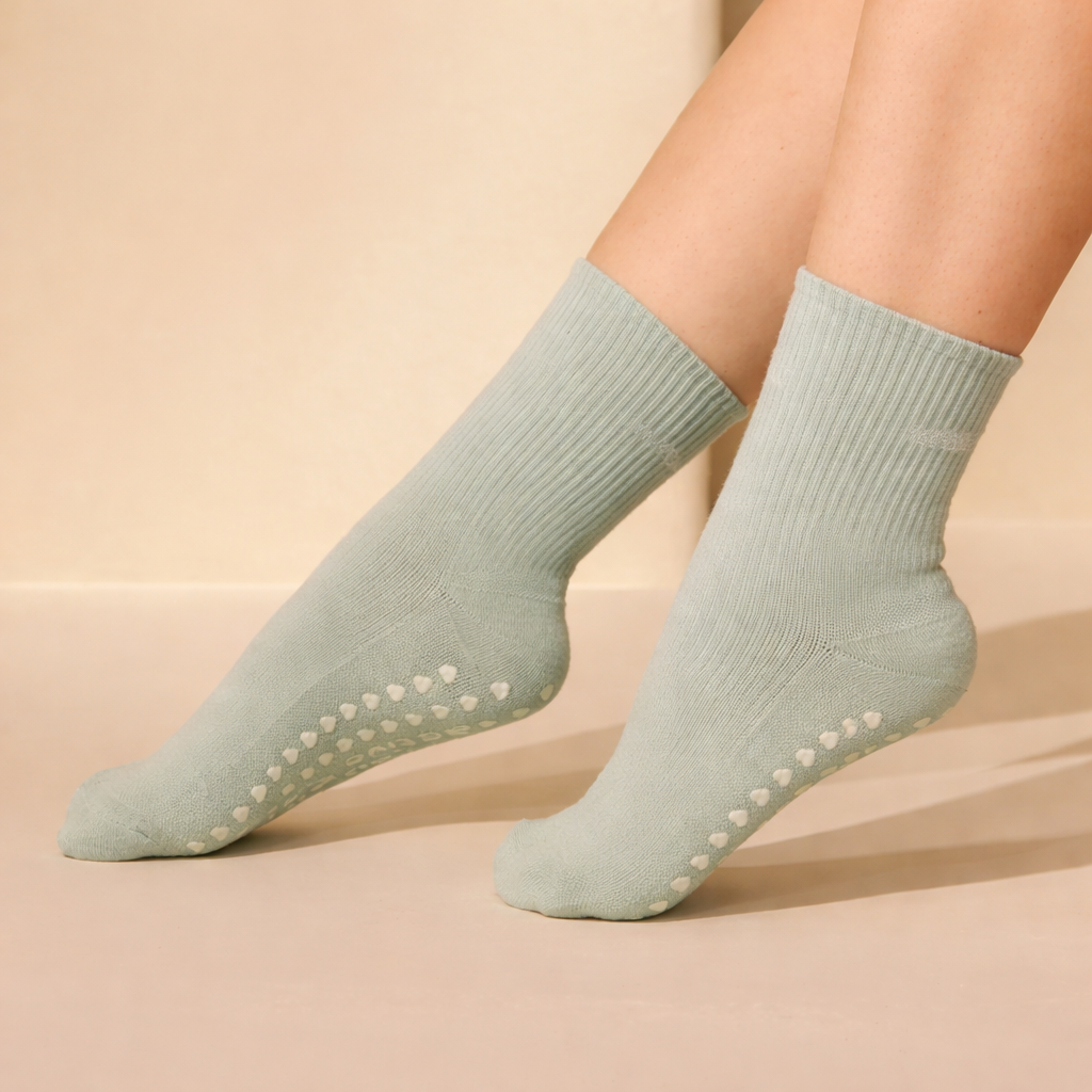 light green wholesale pilates grip socks on feet with silicone grips touching smooth studio floor, pilates socks bulk use