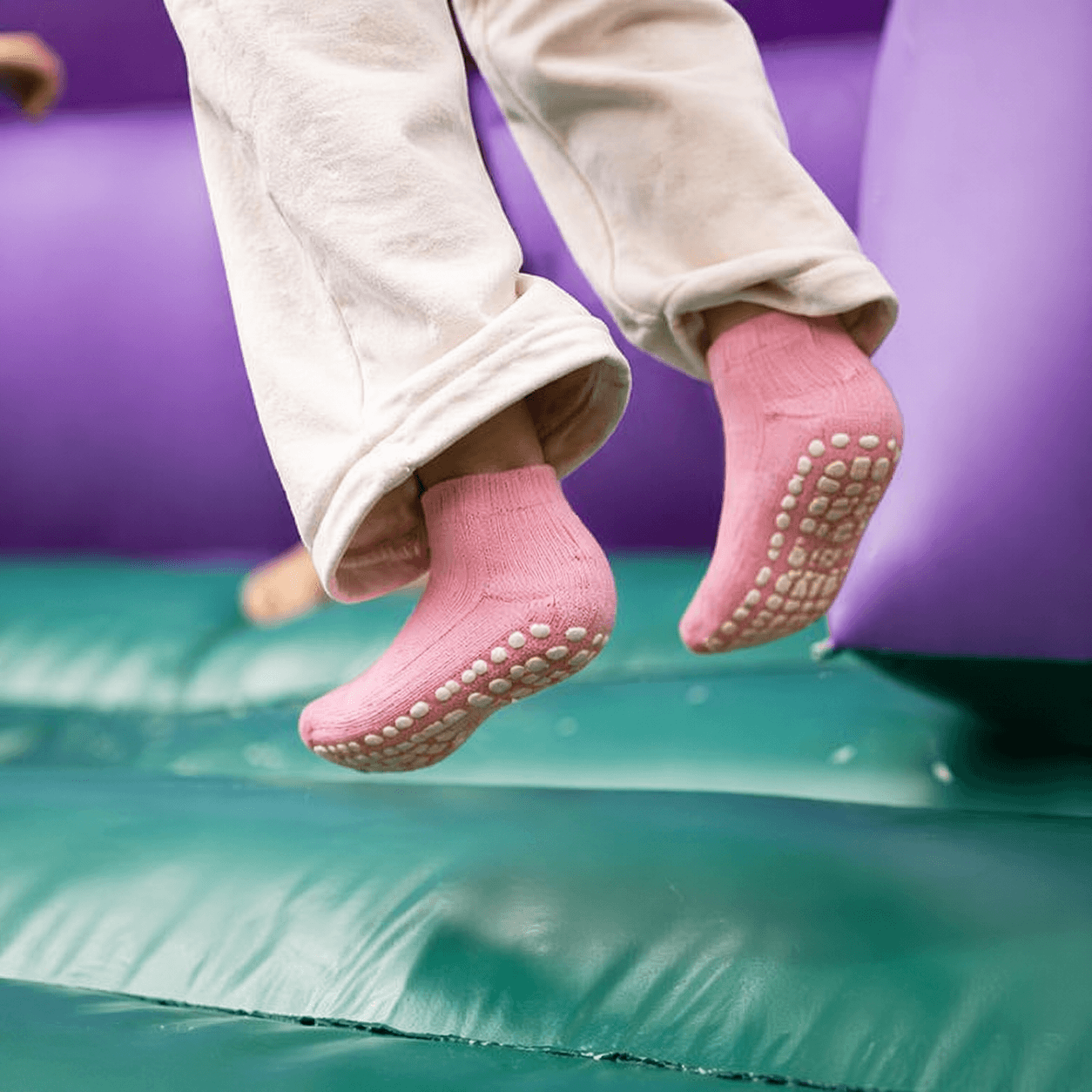 trampoline socks safety on soft play surfaces showing grip socks preventing slipping during jumping activities