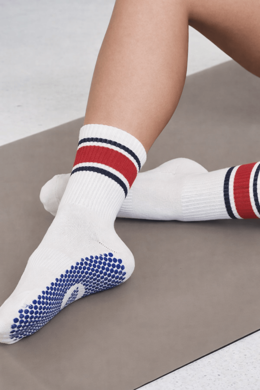 white striped grip socks with silicone grip sole used for fitness and studio activities from private label socks factory