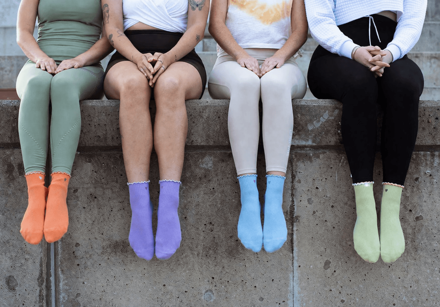 Colorful ruffle-cuff crew pilates grip socks in orange, purple, blue and green, designed to deliver pilates grip socks benefits like slip resistance and comfort, top-rated best pilates grip socks for studio and home use, the best socks for pilates.