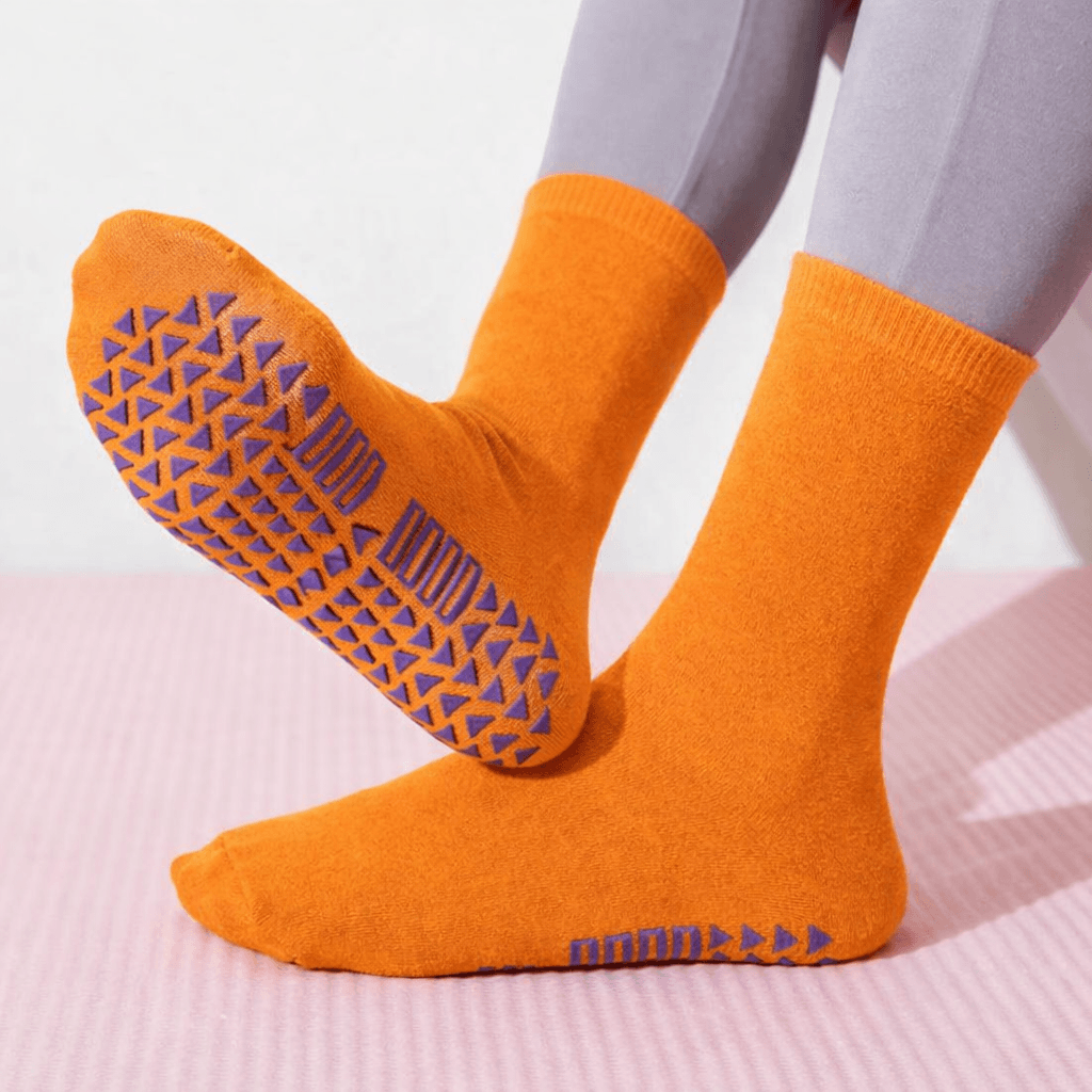 orange grip socks with silicone traction worn on feet demonstrating anti slip performance from OEM grip socks manufacturer