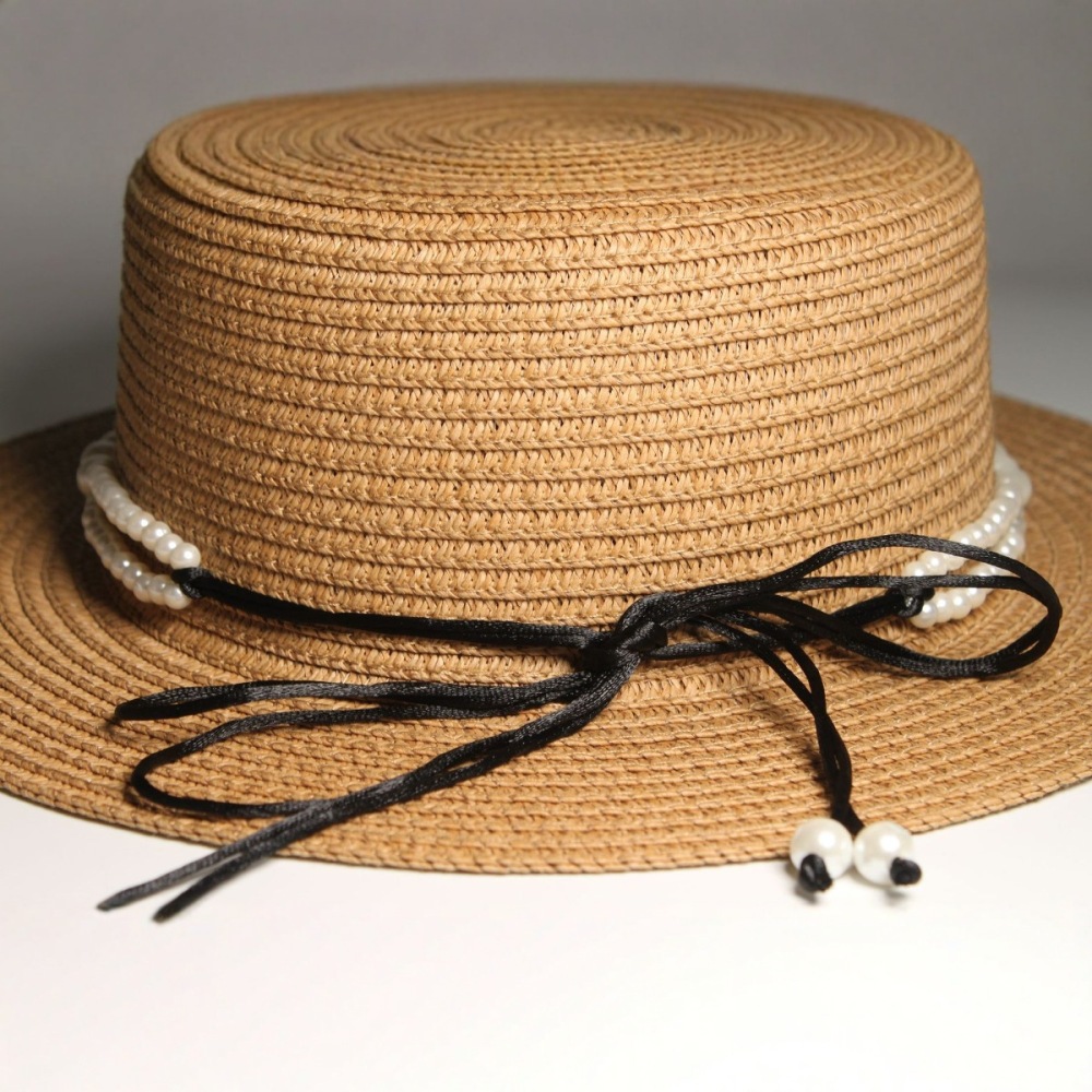 New style round-top straw hat with polka dot ribbon and pearl trim, perfect for beach outings.