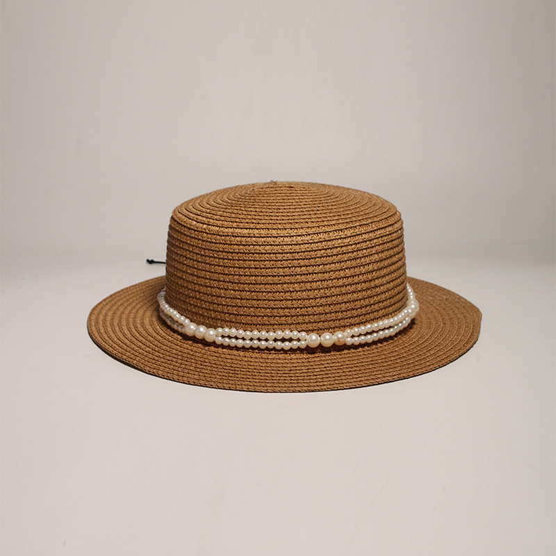 New style round-top straw hat with polka dot ribbon and pearl trim, perfect for beach outings.