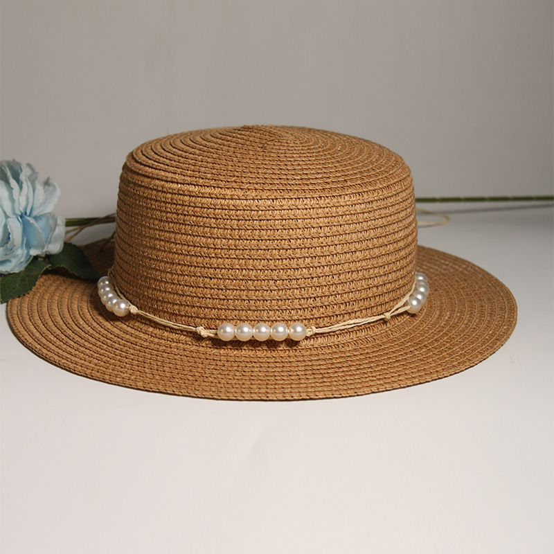 New style round-top straw hat with polka dot ribbon and pearl trim, perfect for beach outings.