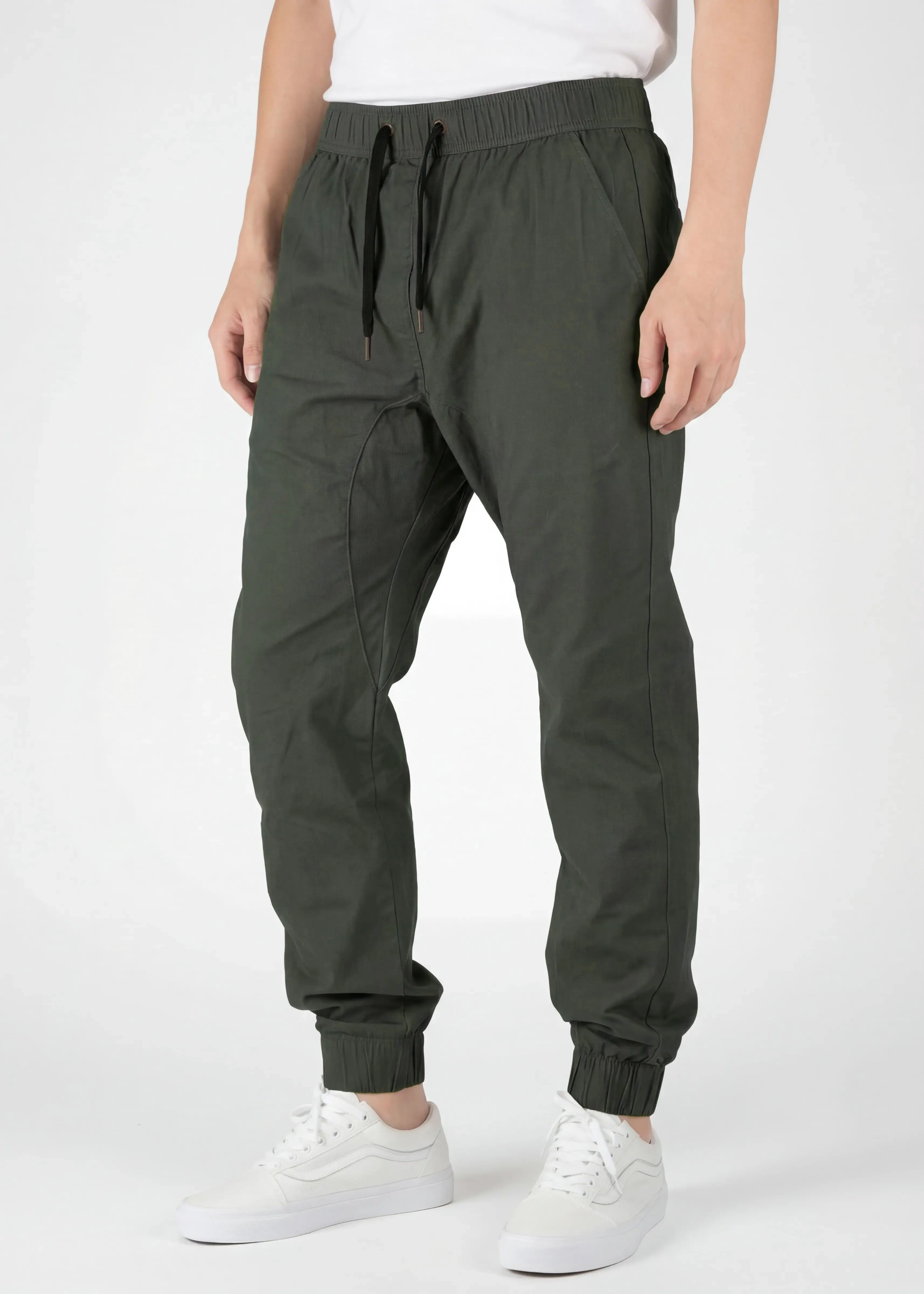  Front view detail of ItalyMorn men's army green jogger pants on a model, highlighting the elastic waistband with black drawstrings, deep side pockets, and slim-tapered fit