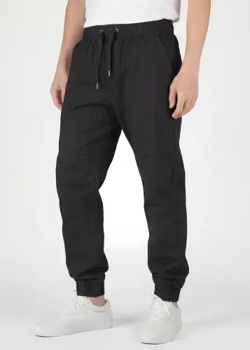  Front view close-up of ItalyMorn men's black jogger pants, featuring a comfortable elastic waistband with adjustable drawstrings, functional side pockets, and a clean slim-fit design
