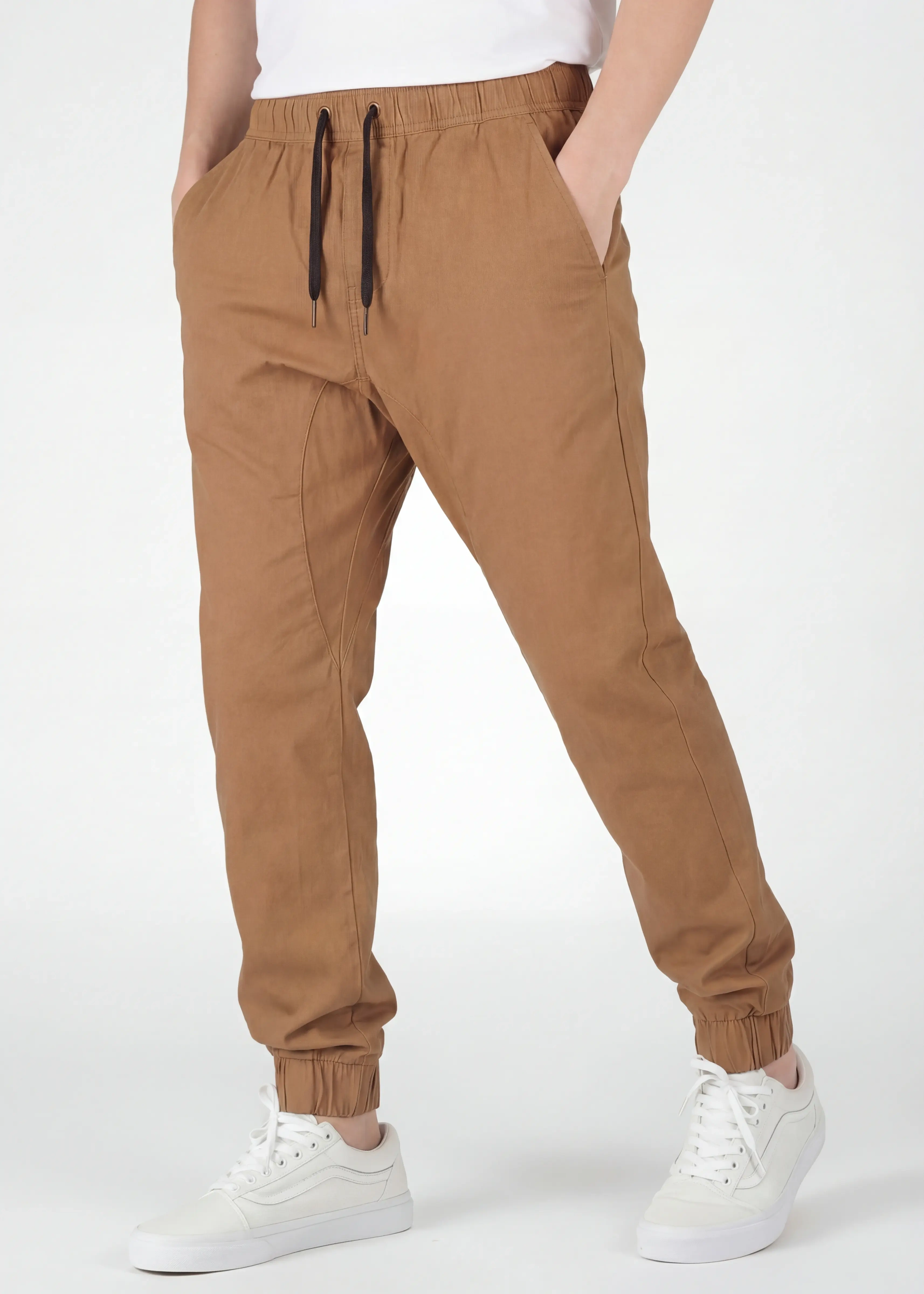  Angled front view of ItalyMorn men's brown jogger pants on a model with one hand in pocket. This highlights the smooth drape of the premium cotton-blend fabric and the versatile everyday fit