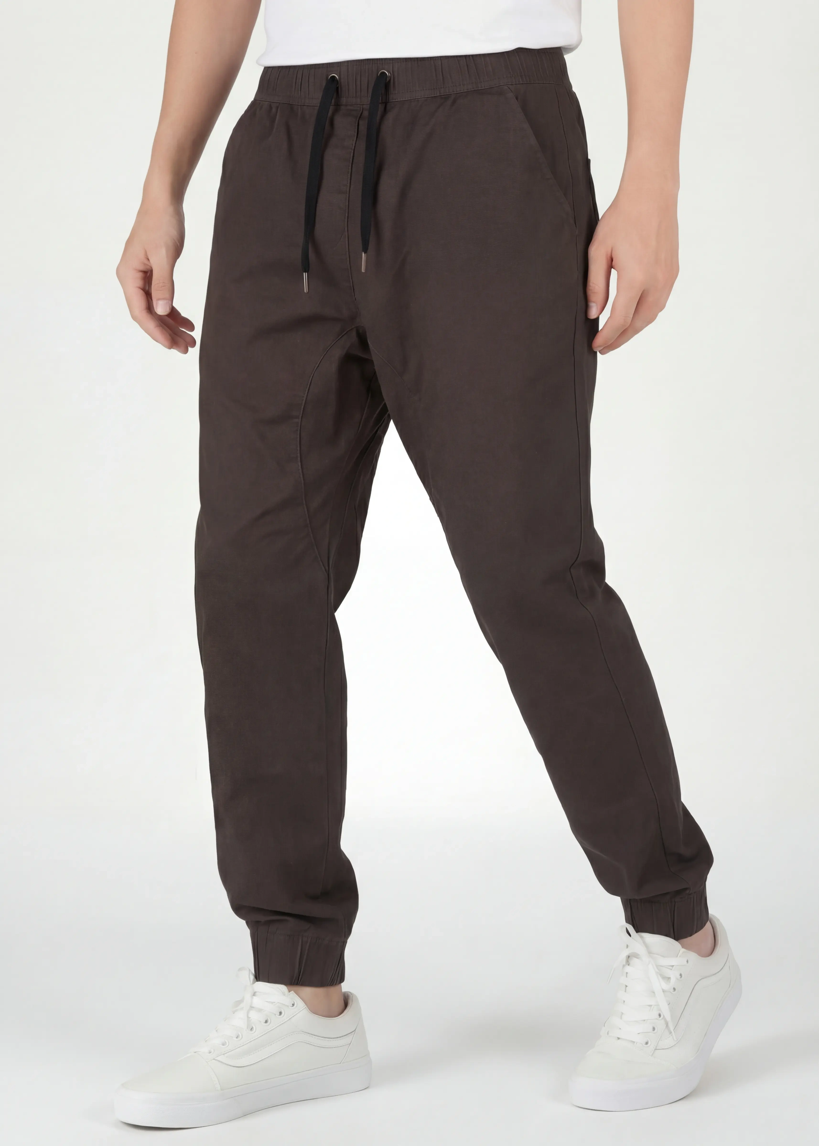 Angled front view of ItalyMorn men's coffee brown jogger pants mid-step, emphasizing the smooth drape of the premium fabric, reinforced side seams, and flexible everyday fit
