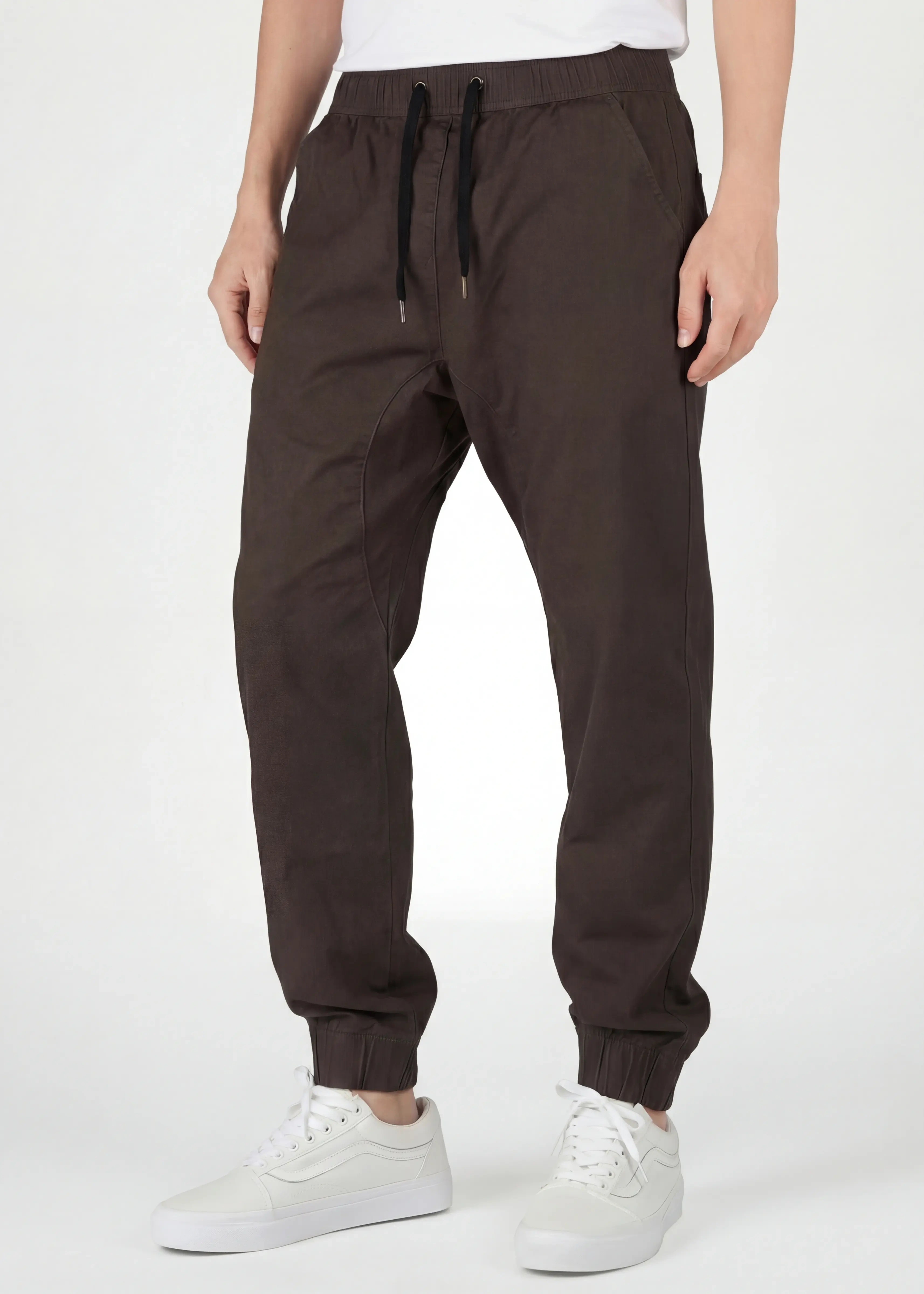  Front close-up of ItalyMorn men's coffee brown jogger pants, featuring an adjustable elastic waistband with black drawstrings, deep functional side pockets, and a clean tailored look.