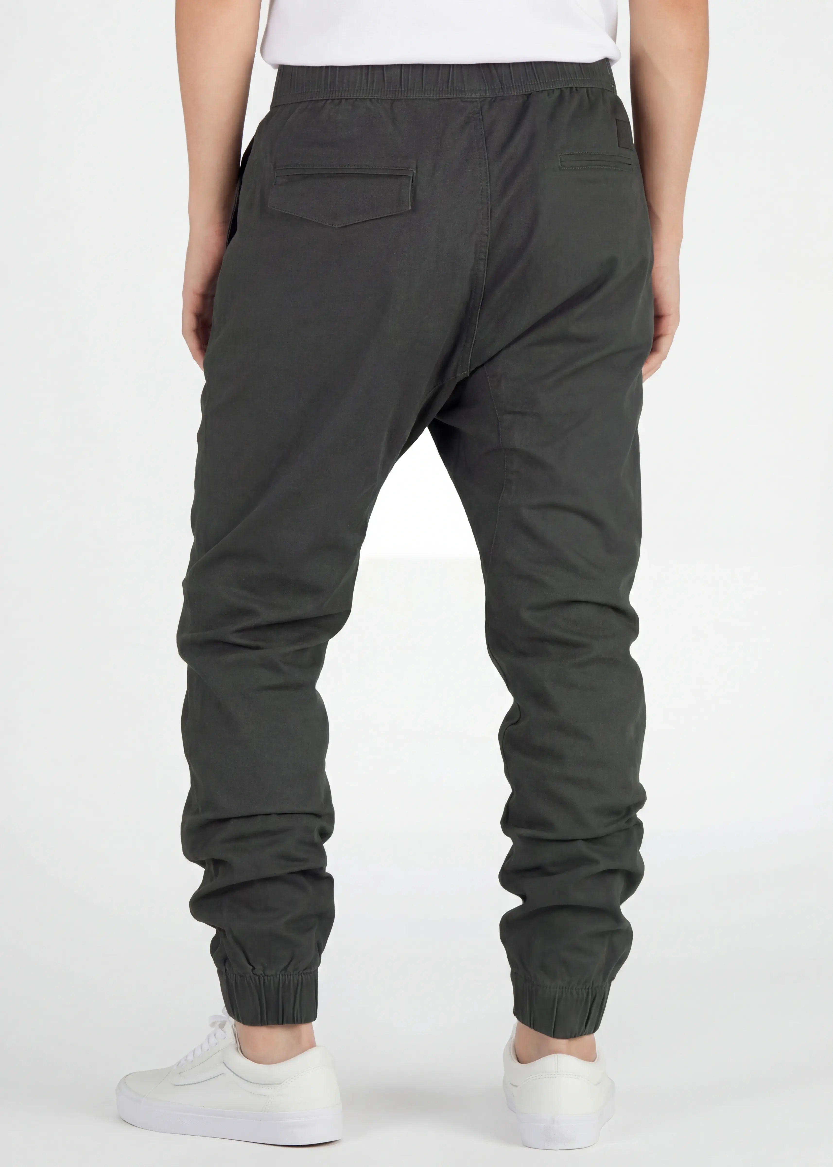 Back view of ItalyMorn men's dark grey green jogger pants on a model, highlighting the well-tailored seat, secure back pockets, and comfortable ribbed ankle cuffs