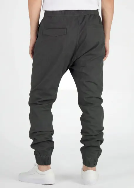 Back view of ItalyMorn men's dark grey green jogger pants on a model, highlighting the well-tailored seat, secure back pockets, and comfortable ribbed ankle cuffs