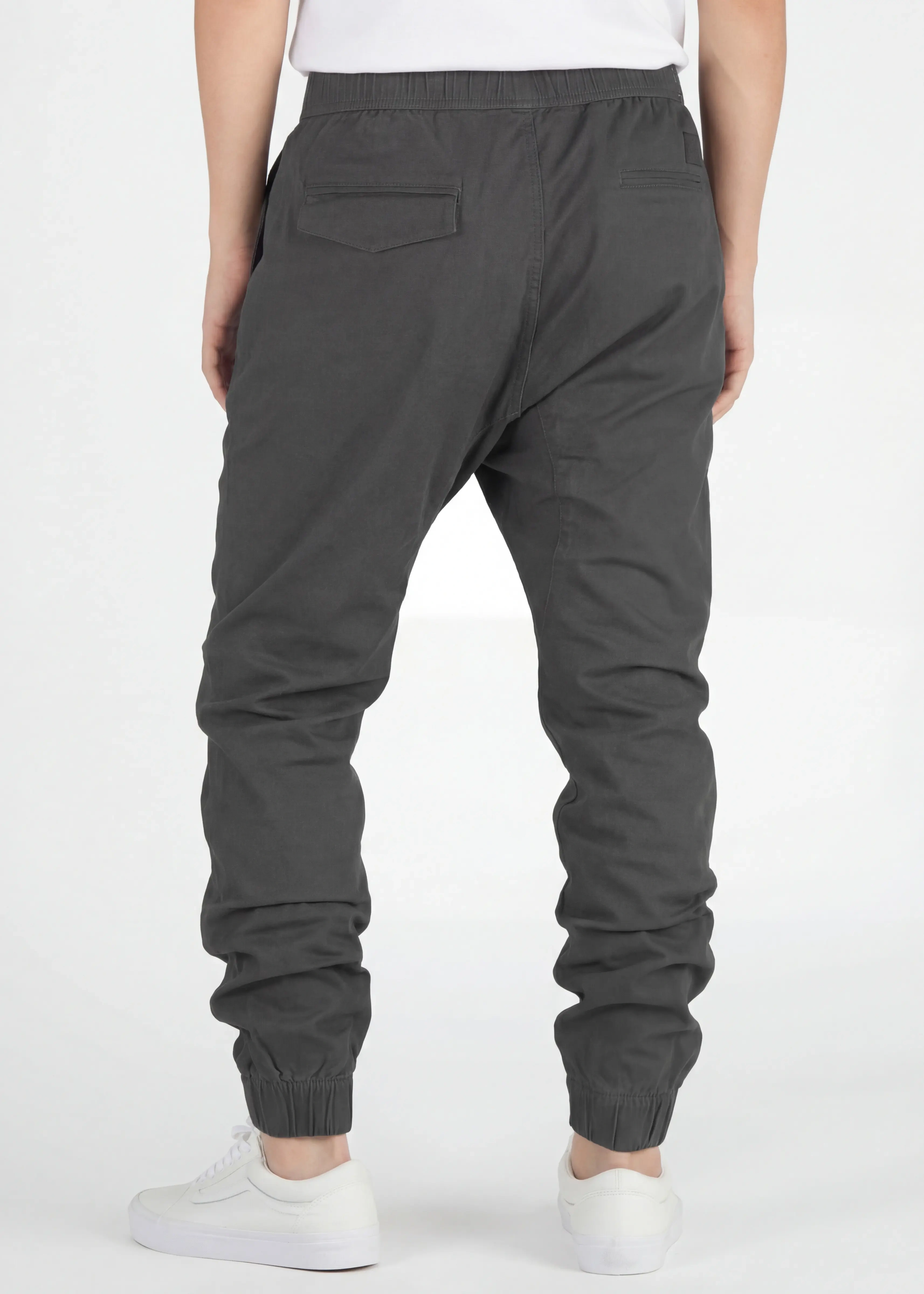Back view of ItalyMorn men's dark grey jogger pants on a model, showcasing the secure back pockets, well-tailored seat, and snug ribbed ankle cuffs