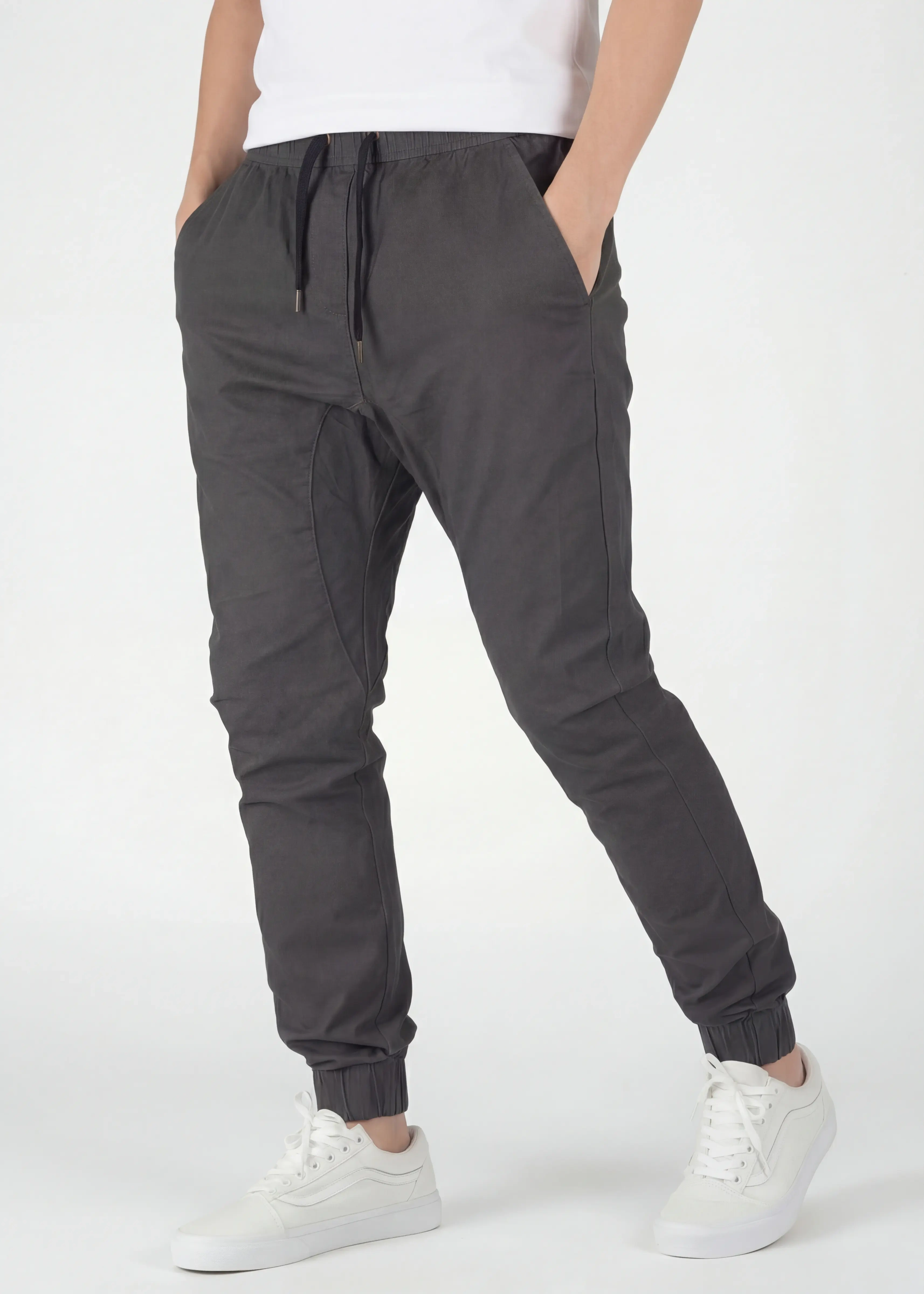 Angled front view of ItalyMorn men's charcoal grey jogger pants, highlighting the smooth drape of the fabric, reinforced side seams, and the versatile, everyday slim fit