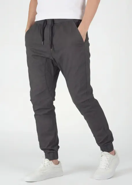 Angled front view of ItalyMorn men's charcoal grey jogger pants, highlighting the smooth drape of the fabric, reinforced side seams, and the versatile, everyday slim fit