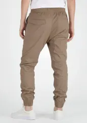 A rear view close-up of ItalyMorn men's dark khaki jogger pants on a model, highlighting the functional back pockets, clean fit, and durable fabric texture. Paired with white sneakers