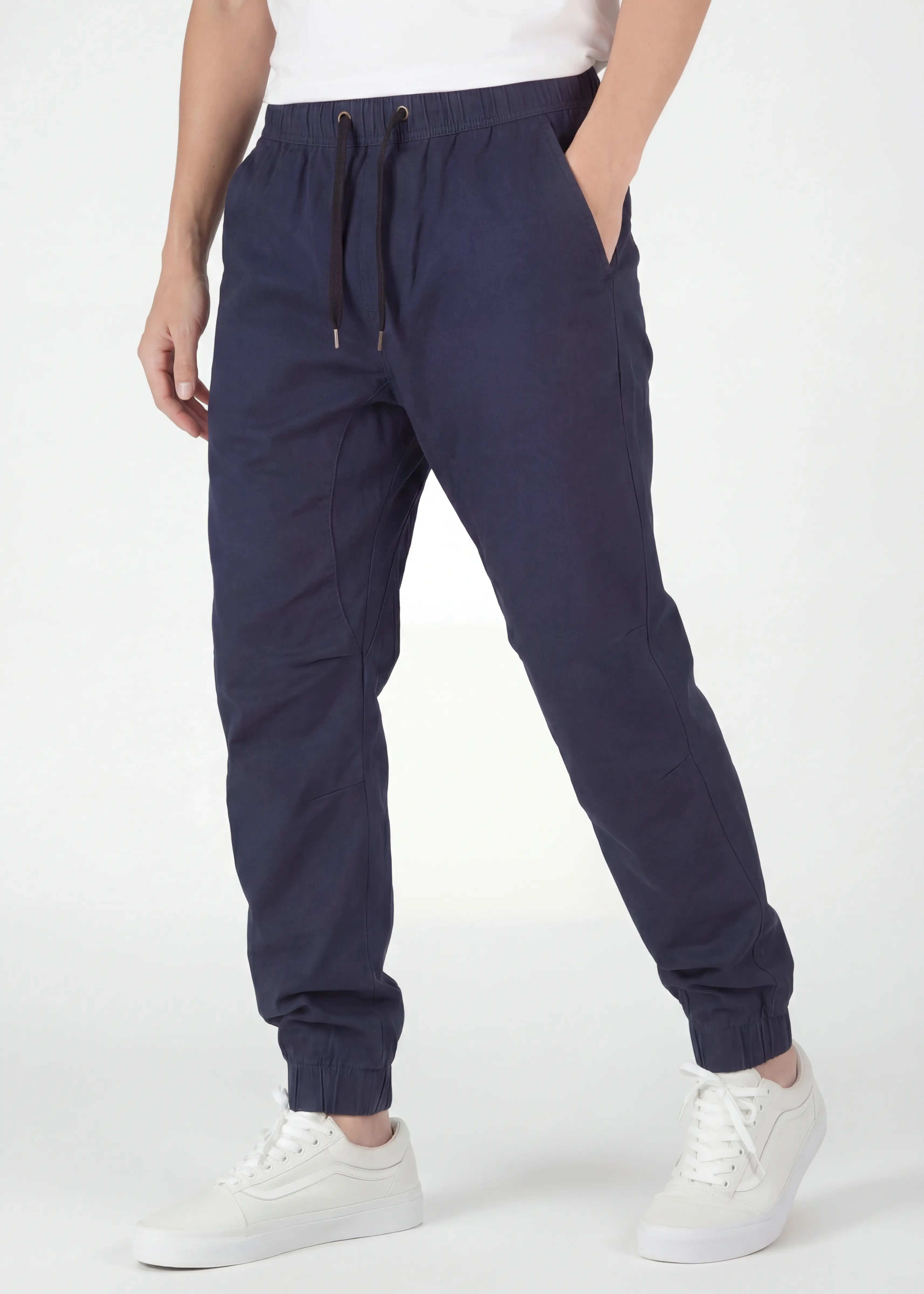  An angled front view of ItalyMorn men's navy blue jogger pants on a model with one hand in pocket. This highlights the smooth drape of the premium fabric, the reinforced side seams, and the versatile everyday fit