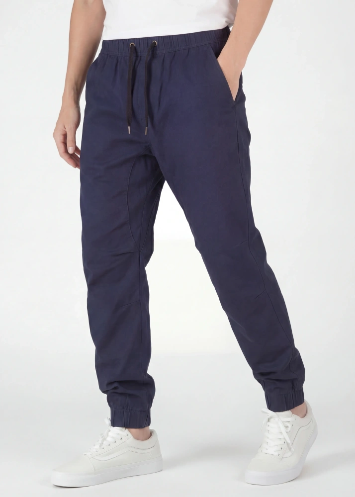  An angled front view of ItalyMorn men's navy blue jogger pants on a model with one hand in pocket. This highlights the smooth drape of the premium fabric, the reinforced side seams, and the versatile everyday fit