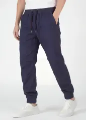  An angled front view of ItalyMorn men's navy blue jogger pants on a model with one hand in pocket. This highlights the smooth drape of the premium fabric, the reinforced side seams, and the versatile everyday fit