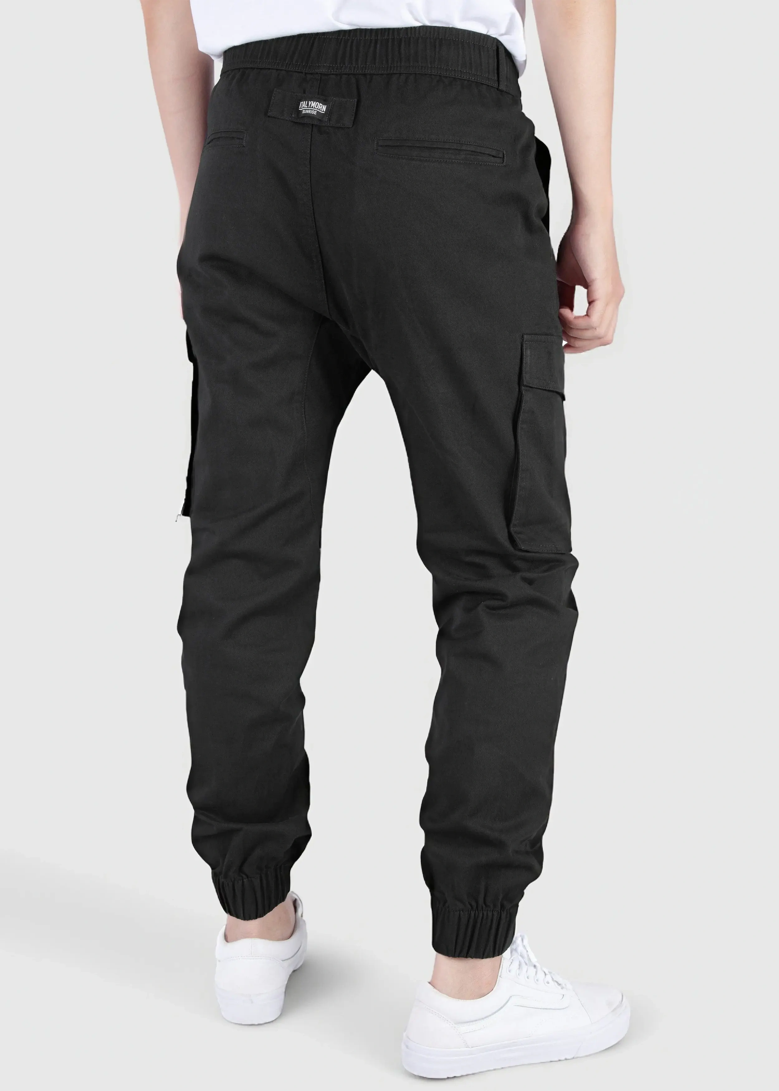 Back view of a male model wearing men's black cargo joggers, showcasing the comfortable elastic waistband, back welt pockets with the ITALYMORN woven brand label, and side cargo pockets.