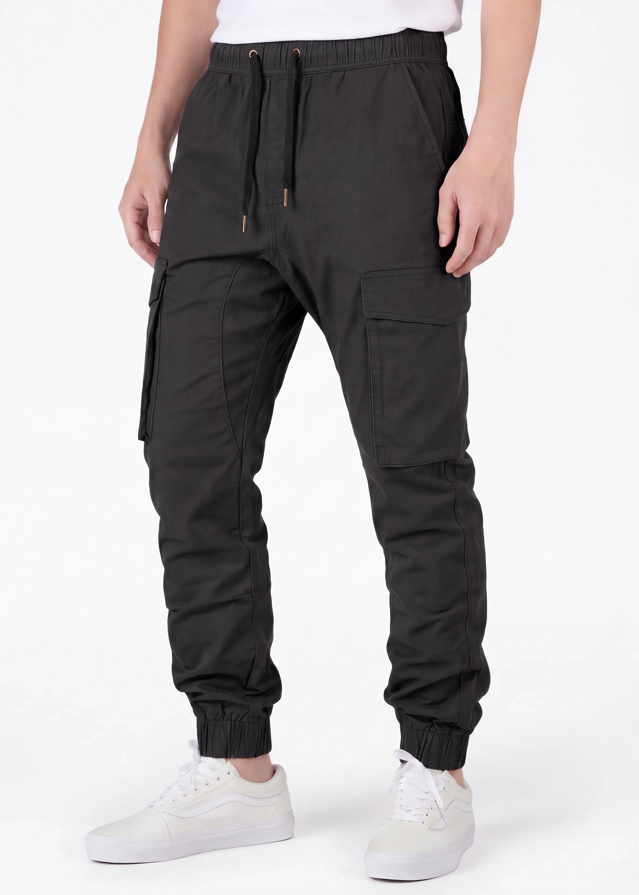 Front view of a male model wearing ITALYMORN men's black cargo joggers, featuring an elastic waistband with drawstrings, side cargo pockets, and ankle cuffs, paired with white sneakers.