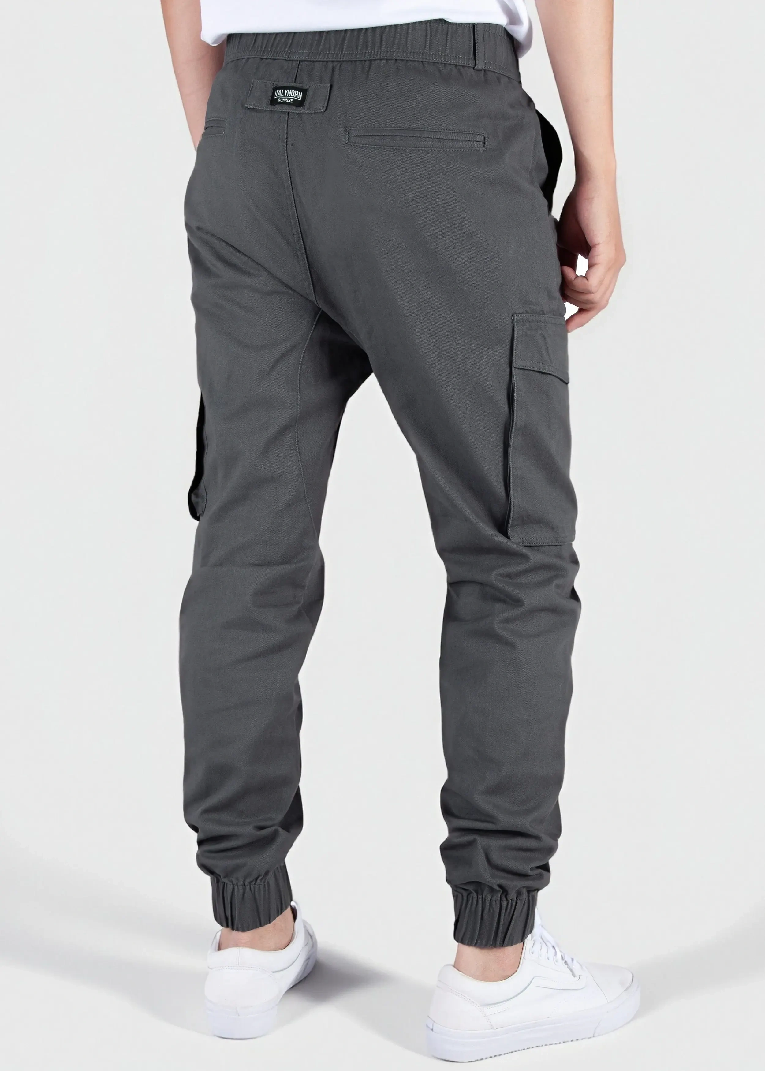 Back view of a male model wearing men's dark grey cargo joggers, showcasing the comfortable elastic waistband, back welt pockets with the ITALYMORN woven brand label, and side cargo pockets.