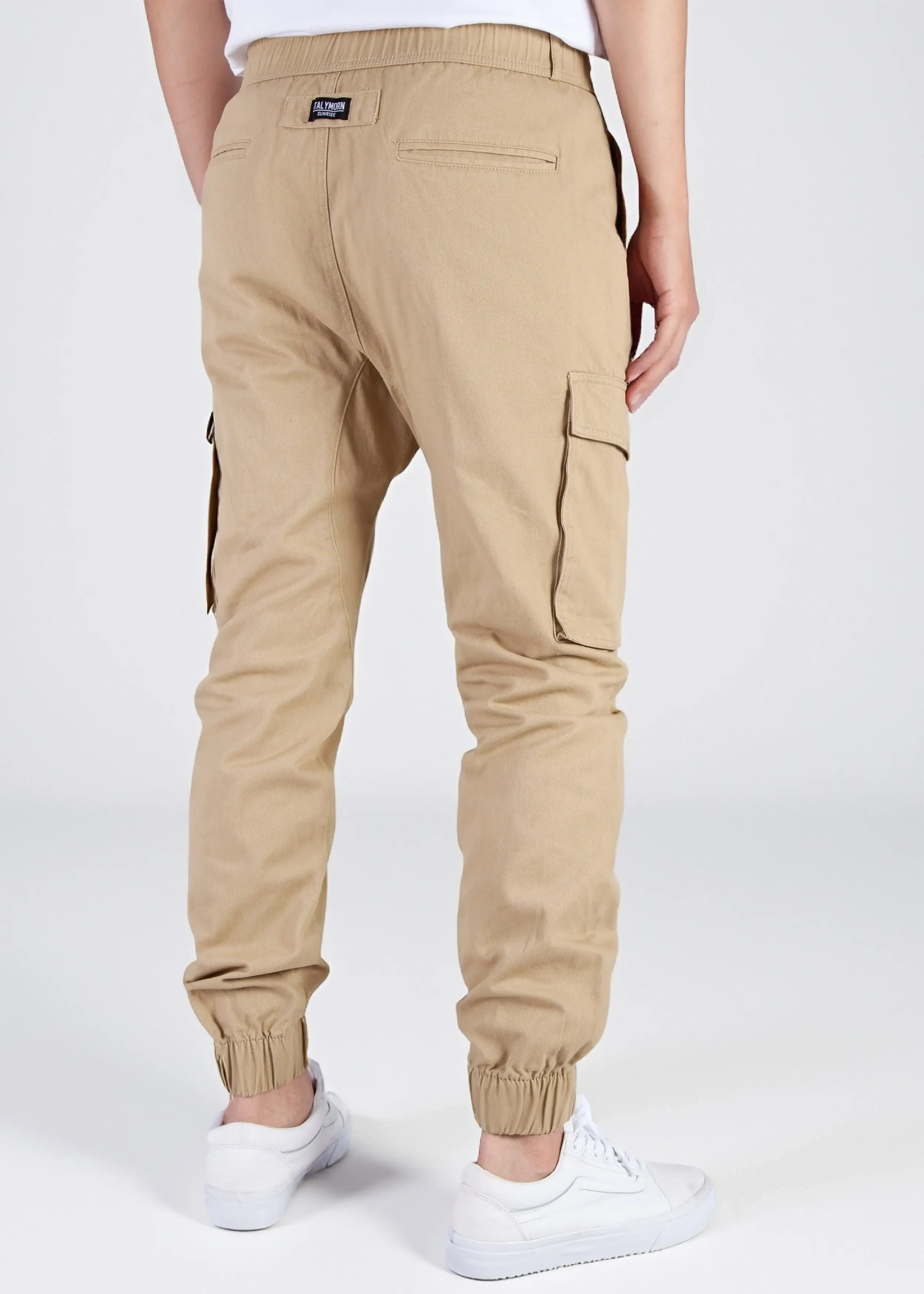 Back view of a male model wearing men's khaki cargo joggers, showcasing the comfortable elastic waistband, back welt pockets with the ITALYMORN woven brand label, and side cargo pockets.