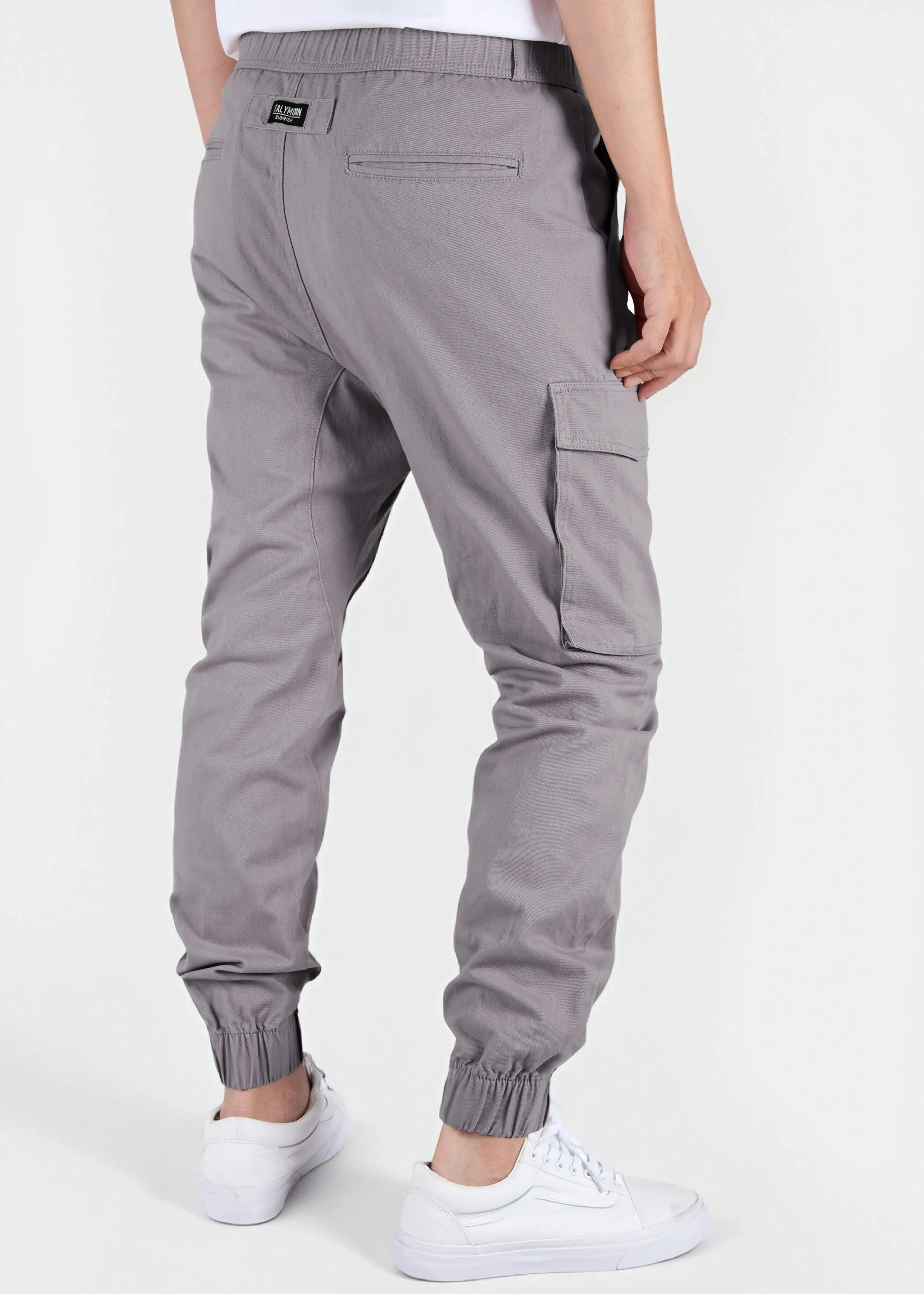 Back view of a male model wearing men's mid grey cargo joggers, showcasing the comfortable elastic waistband, back welt pockets with the ITALYMORN woven brand label, and side cargo pockets.