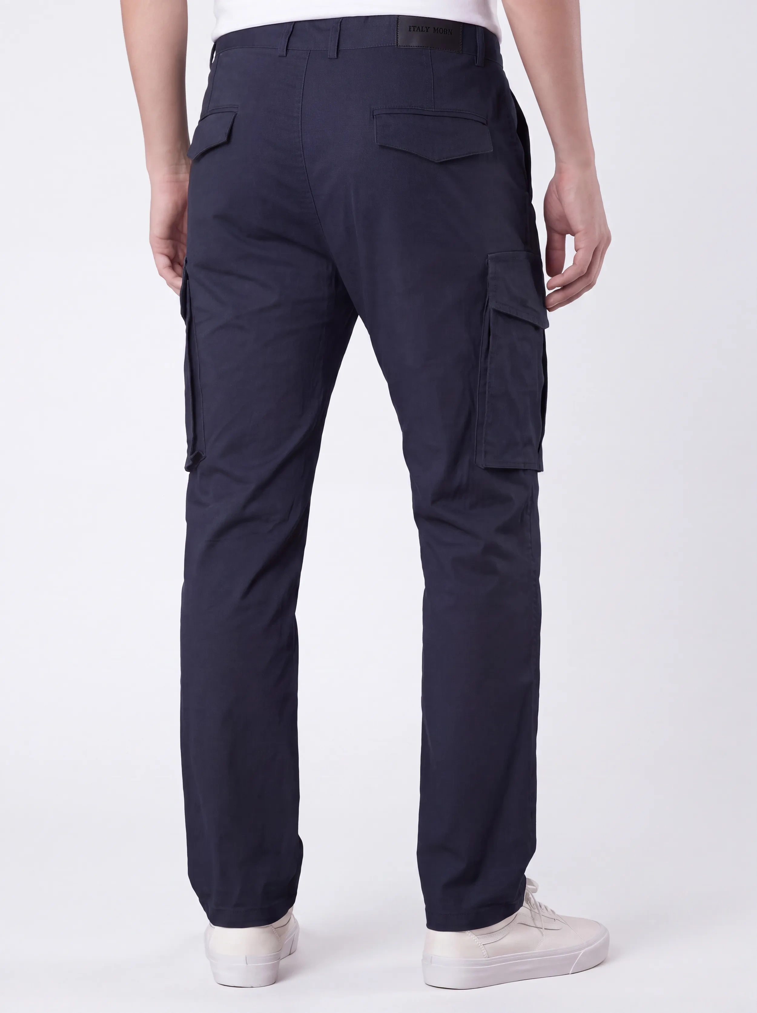 Back view of a male model wearing men's dark blue cargo pants, showcasing a tailored fit, secure flap back pockets with the ITALYMORN brand patch, and a reinforced waistband.